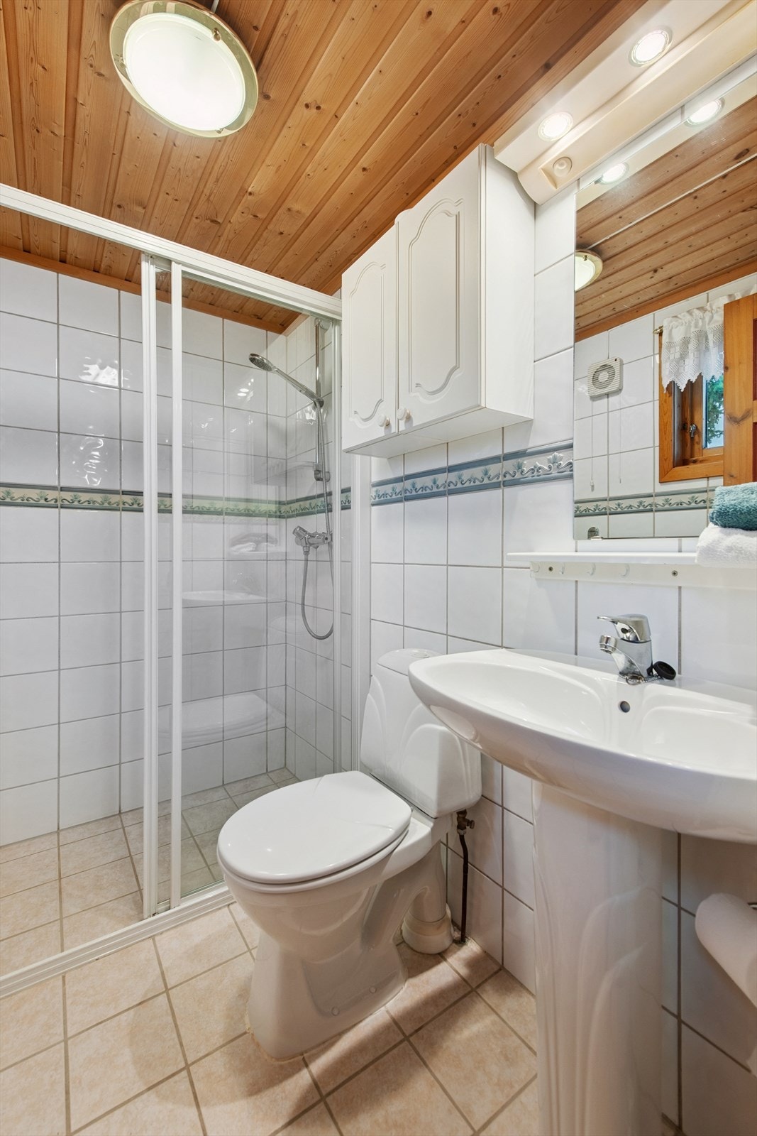 Flislagt bad i 1. etasje med elektrisk gulvvarme. Dusjhjørne, søylevask og toalett. Galleribilde