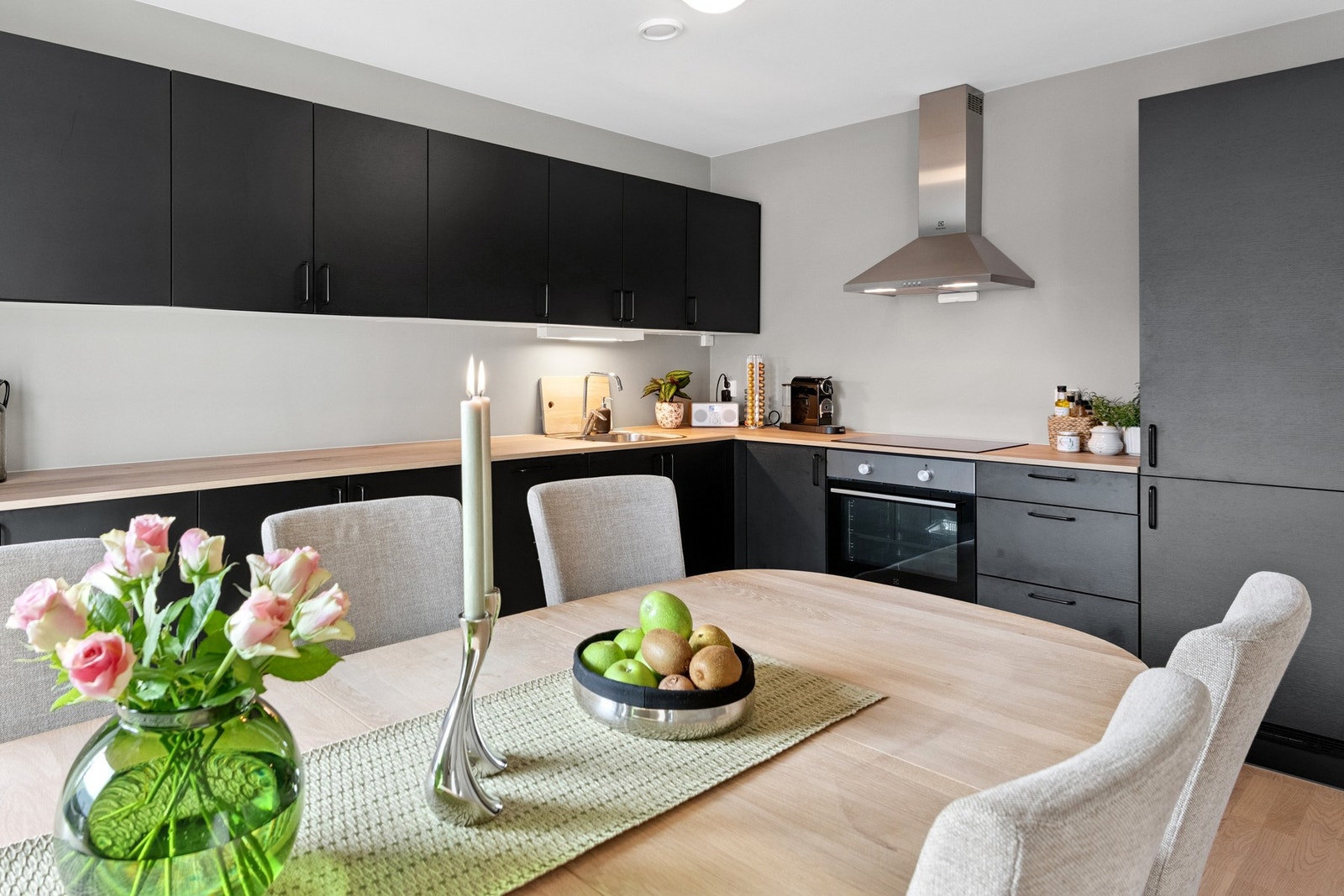 Innbydende kjøkken med sorte fronter. Integrerte hvitevarer som medfølger i handelen. Galleribilde