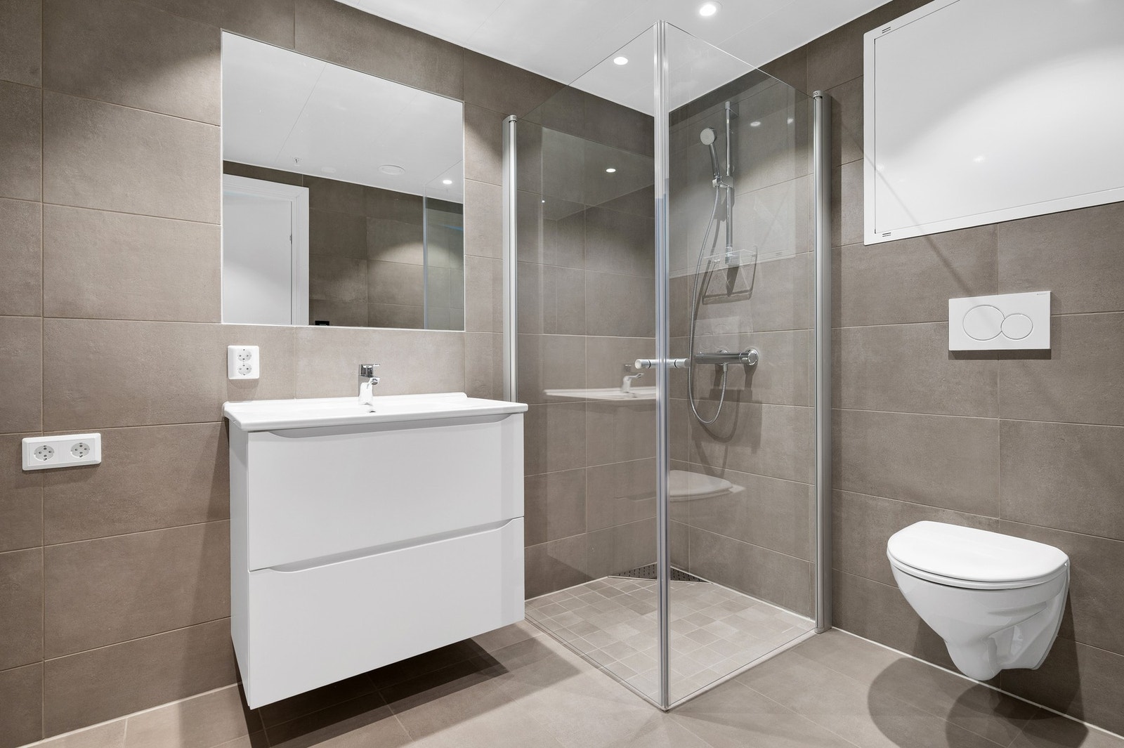 Hovedsoverommet har et eget bad på 4,7 kvm. Badet er flislagt og har gulvvarme, vegghengt wc, servant, dusjhjørne og opplegg for vaskemaskin. Galleribilde