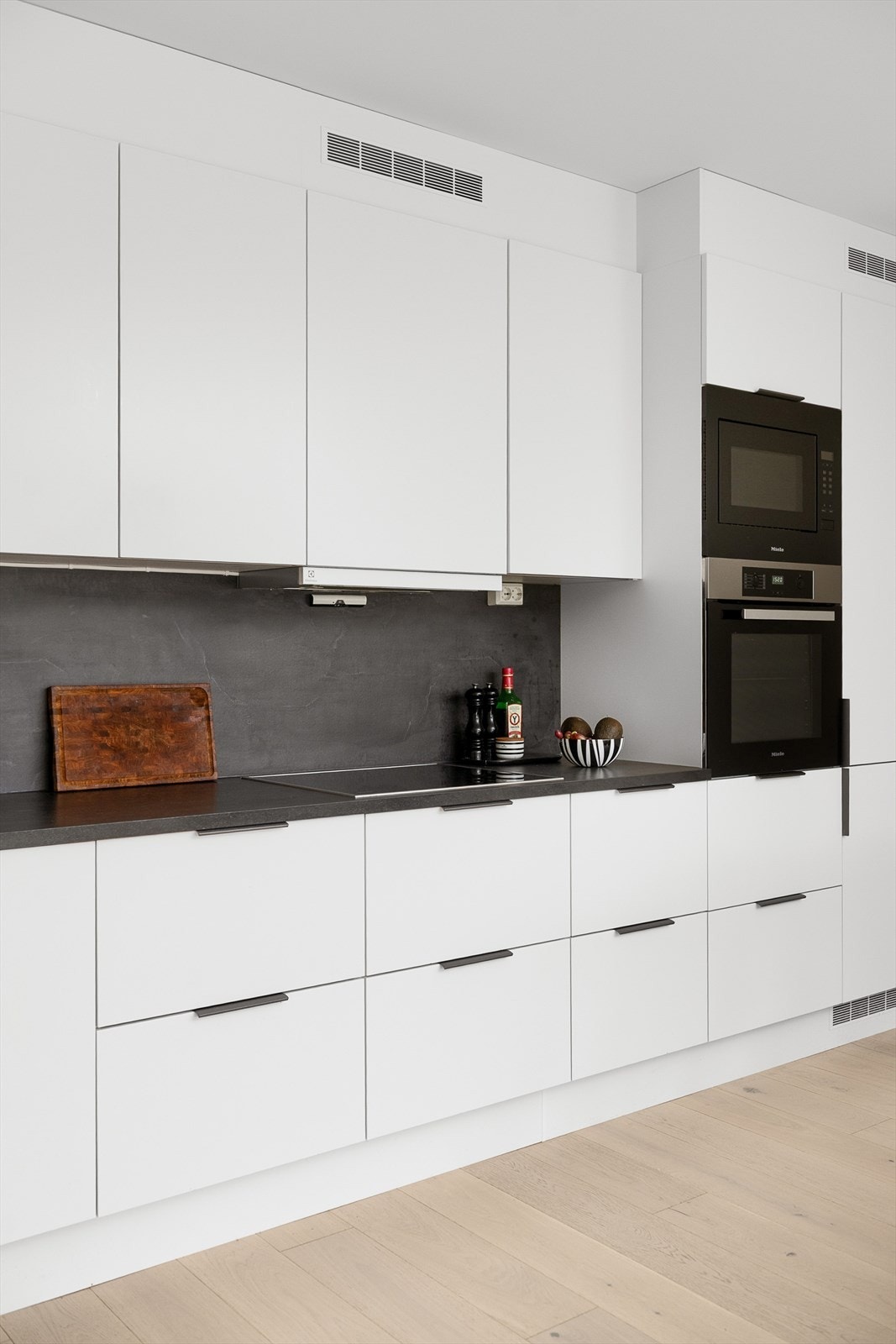 Mørk benkeplate og detaljer gir en fin kontrast til hvit høyglans Galleribilde