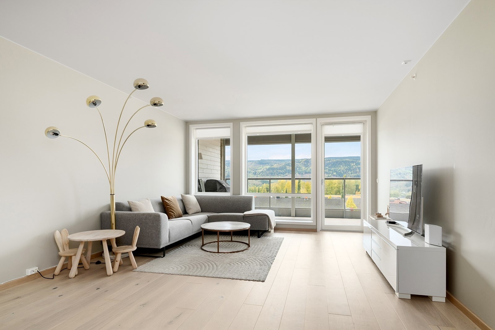 Romslige vestvendte vinduer gir flott utsikt og naturlig lys til stuen Galleribilde