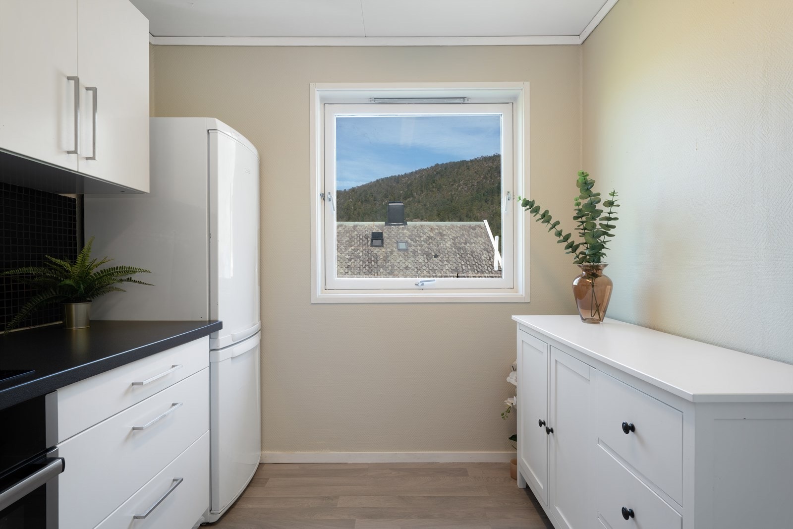 - Kjøkkenet har kjøkkeninnredning med slette fronter og benkeplate i laminat - Galleribilde