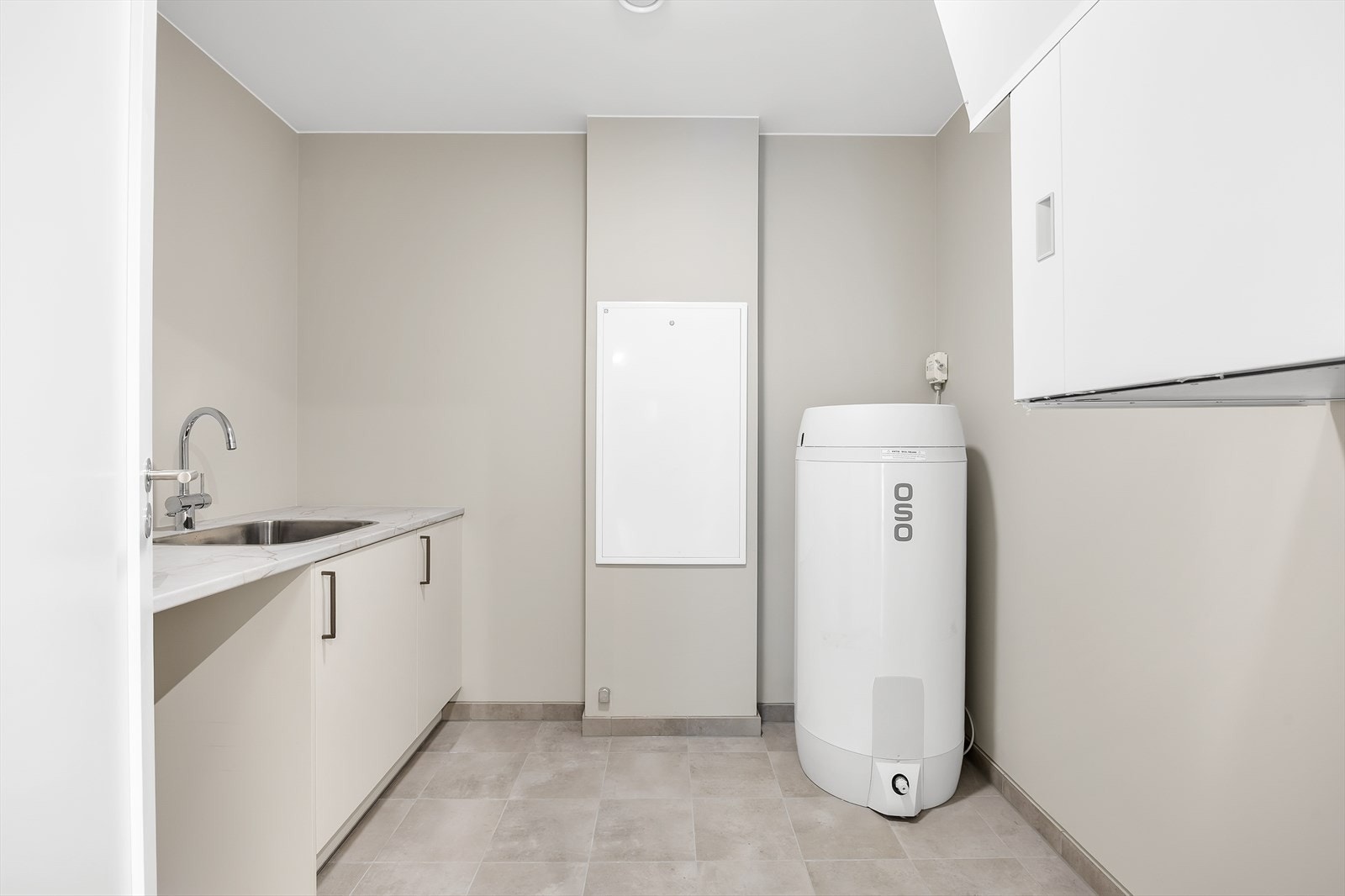 Her er det installert benkeplate med utslagskum, skapløsning under benkeplate samt satt av plass til både vaskemaskin og tørketrommel. Galleribilde