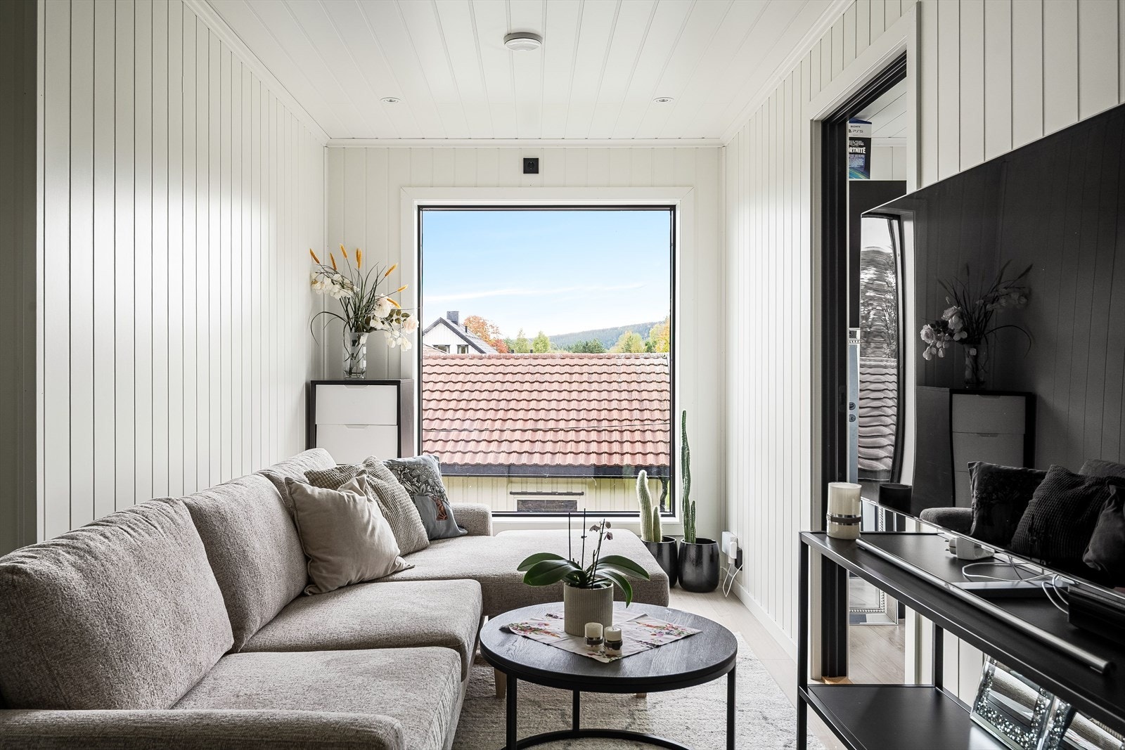 Lys og fin stue med et stort vindu som slipper inn rikelig med naturlig lys. Galleribilde