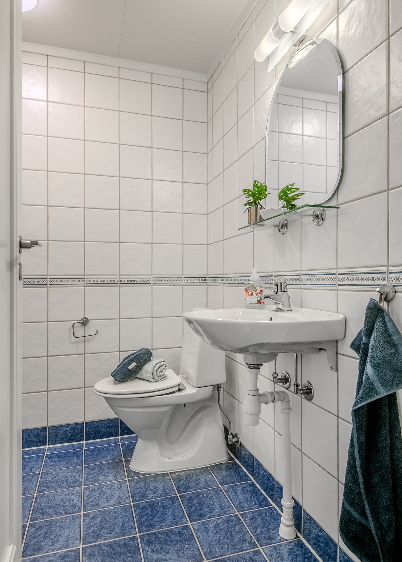 Fliser på gulv og vegger, varmekabler, servant med speil og belysning, dusj og gulvstående toalett. Galleribilde