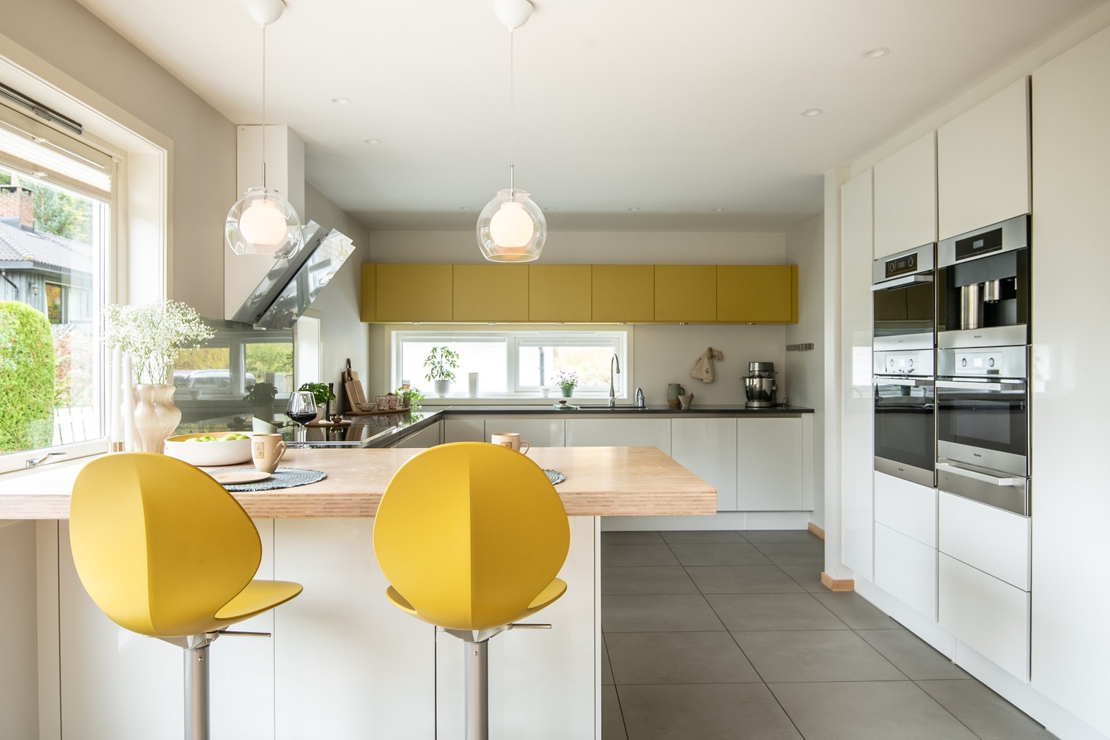 Moderne og innholdsrikt HTH-kjøkken fra 2013 med glatte fronter og benkeplate i steinkompositt. Galleribilde