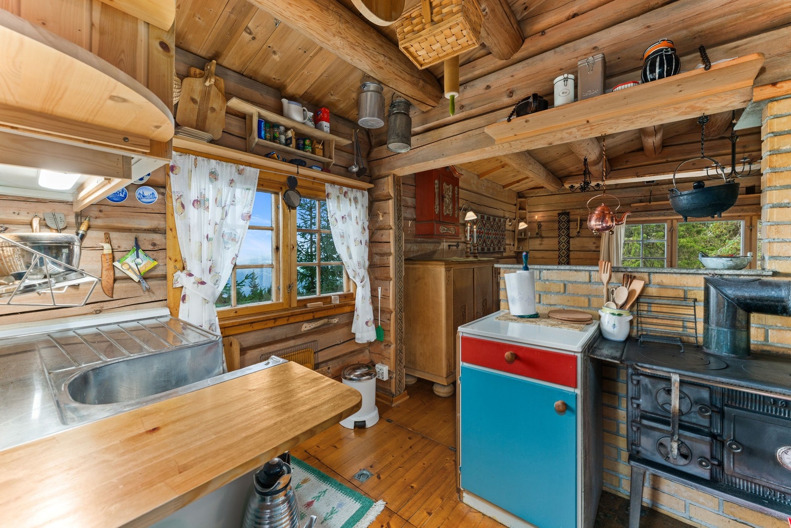 Kjøkkenet har innredning med laminerte skrog og glatte fronter, samt benkeplater i heltre og heldekkende beslag. Galleribilde