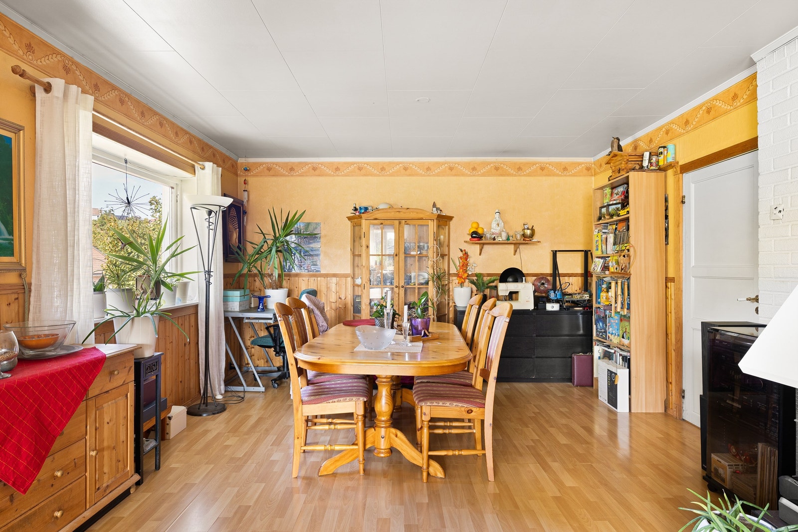 Åpen og fleksibel stue med rikelig dagslys, brede vindusflater og varme fargetoner. Galleribilde