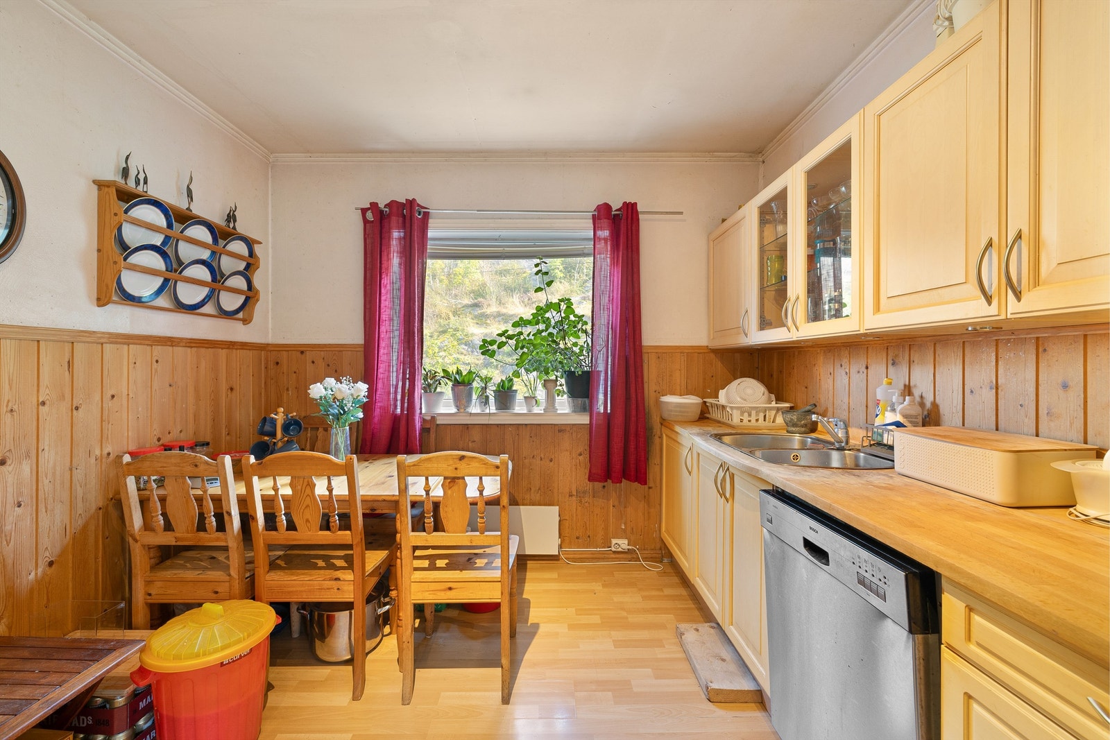 Lys og innbydende kjøkken med vindu mot grøntareal, varme trepaneler og praktisk planløsning. Galleribilde