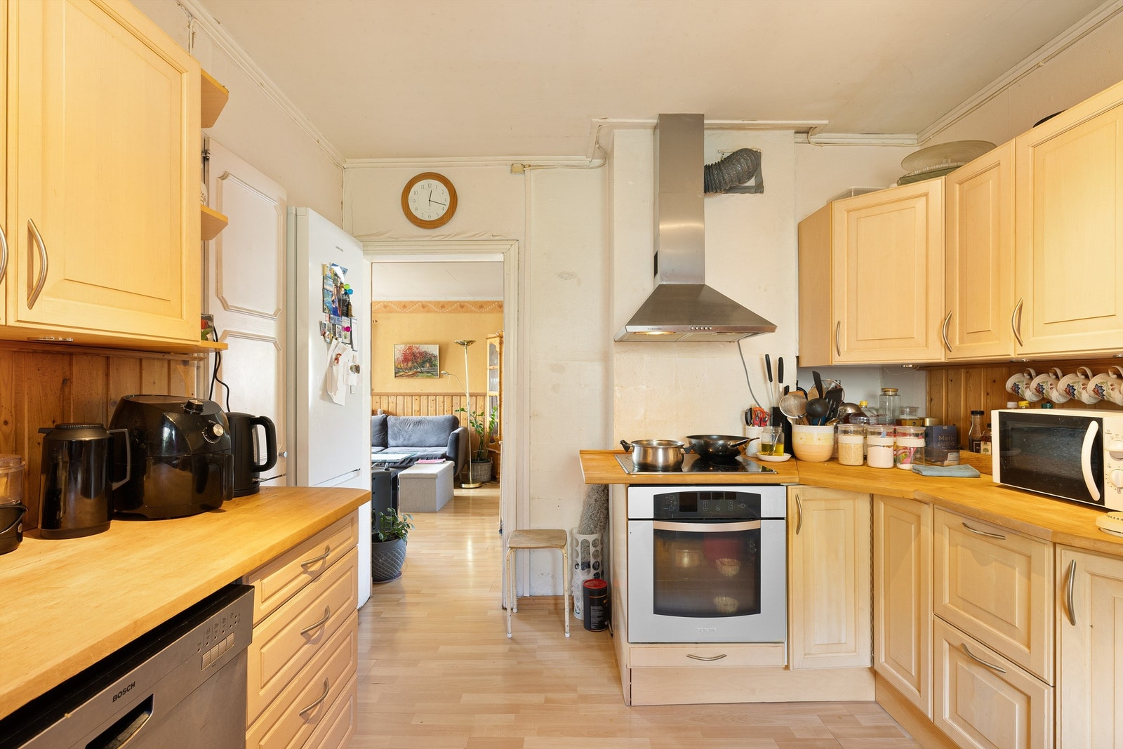 Kjøkkenet har gjennomgangsplan mot stue, lyse tresoner og effektiv benkeplass som gir rikelig med arbeidsplass på kjøkkenet. God oppbevaring i skap. Galleribilde