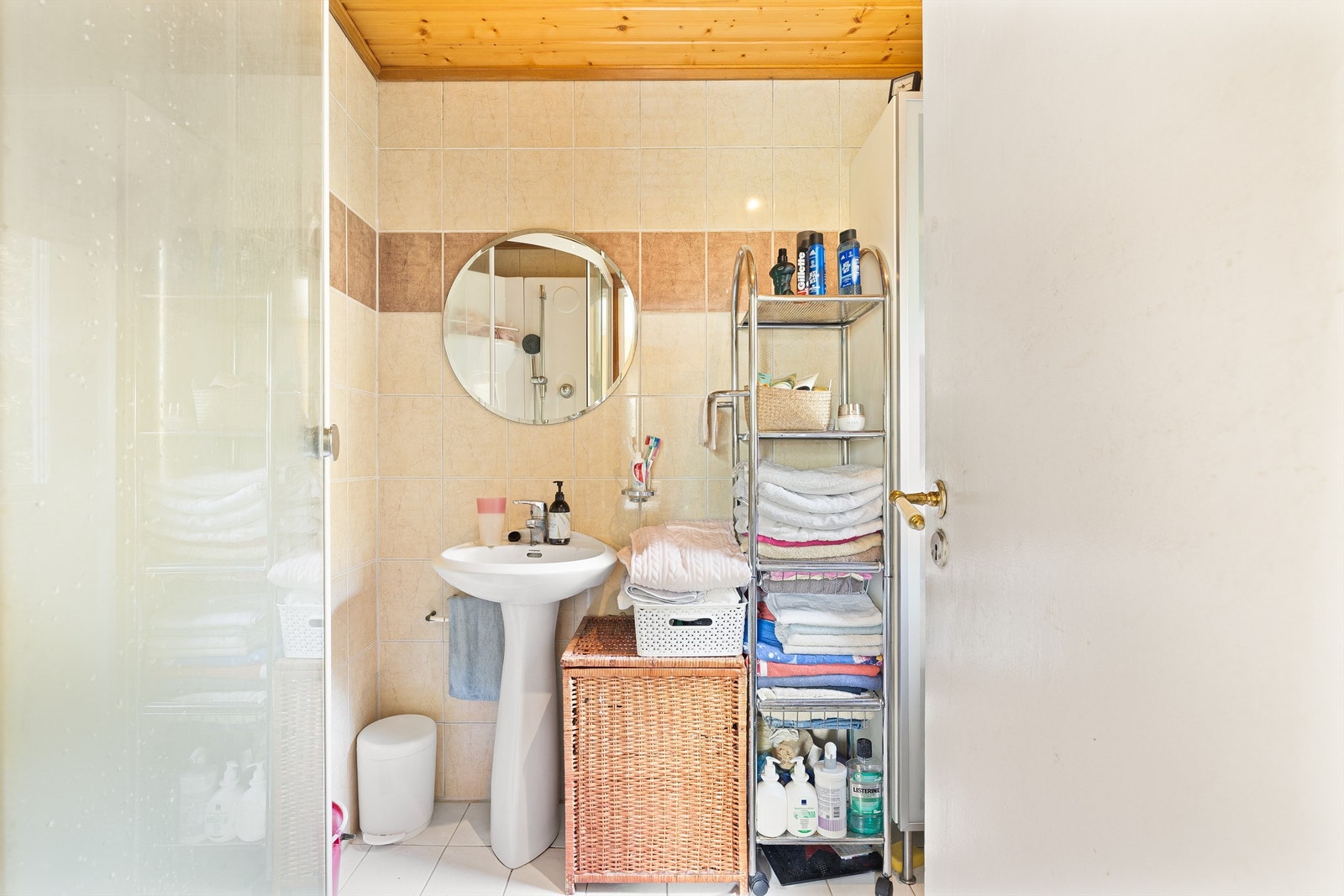 Badet har flislagte vegger med dekorstripe og et varm trehimling. Galleribilde