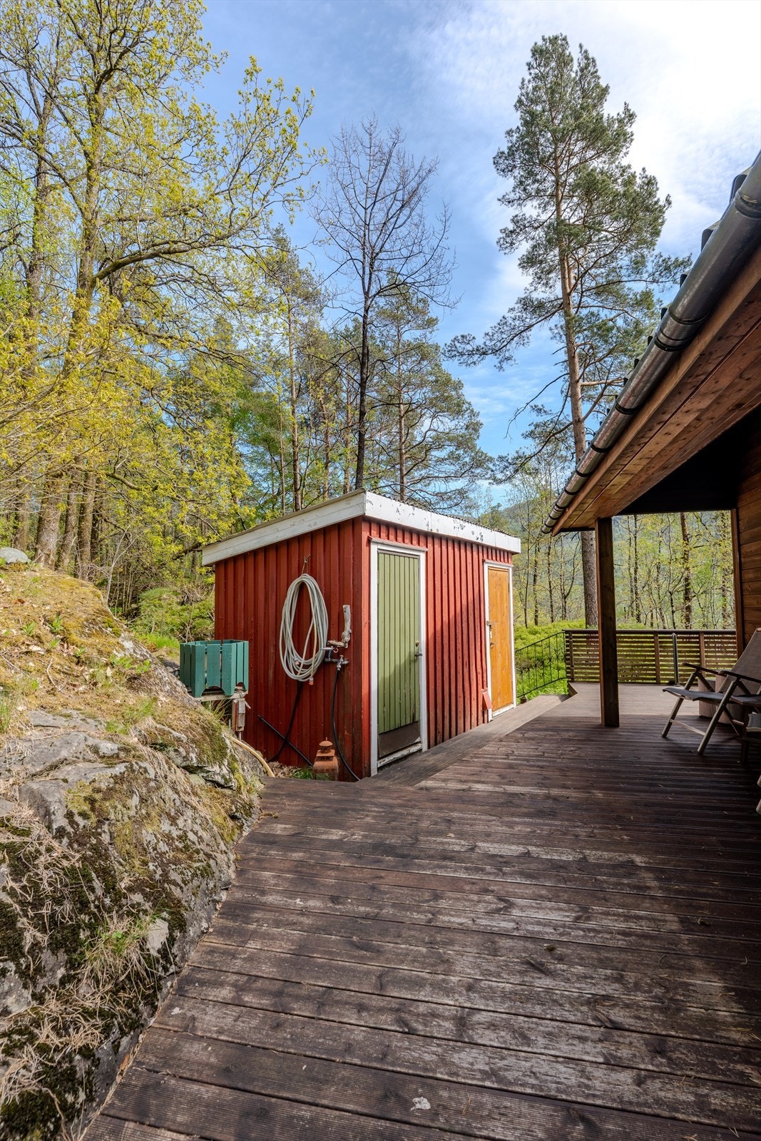 Vannslange fra liten brønn på vegg uthus Galleribilde