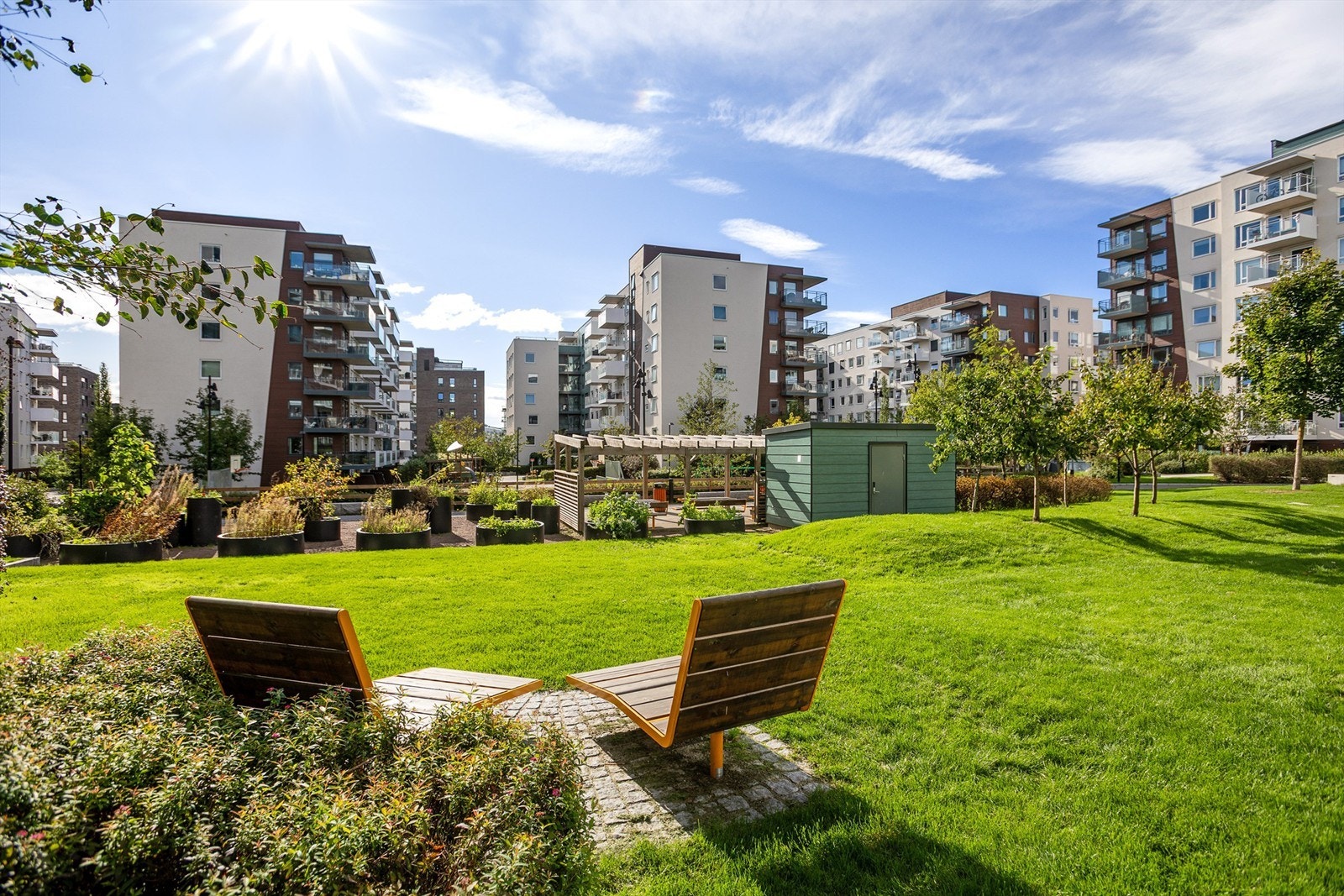 Felles tomt med lekeplasser, plantekasser, grillplass, fontene, aktivitetspark og sittegrupper Galleribilde