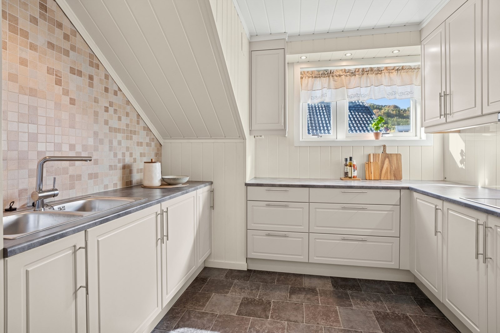 Kjøkkenet har godt med skap og benkeplass. Galleribilde