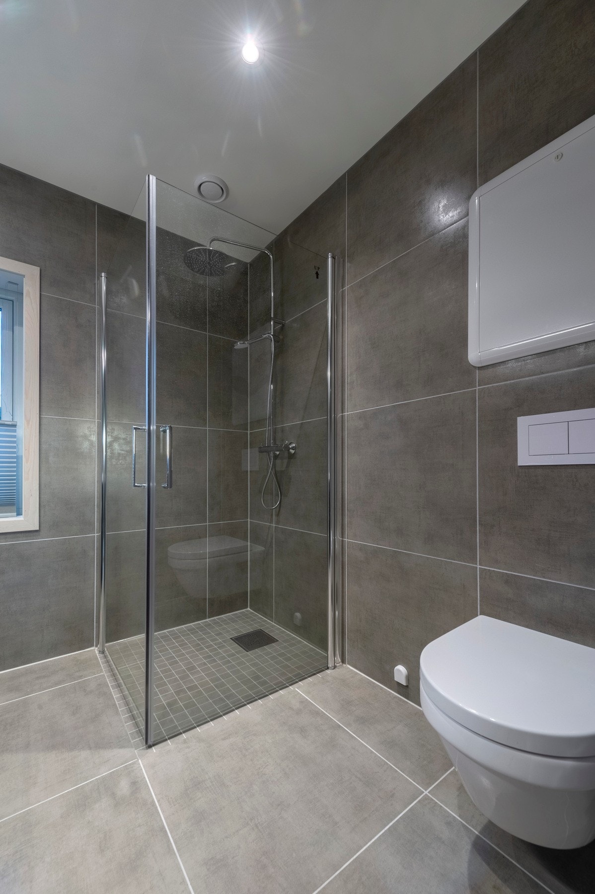 Fliser på gulv og vegger med varmekabler i gulvet. Galleribilde