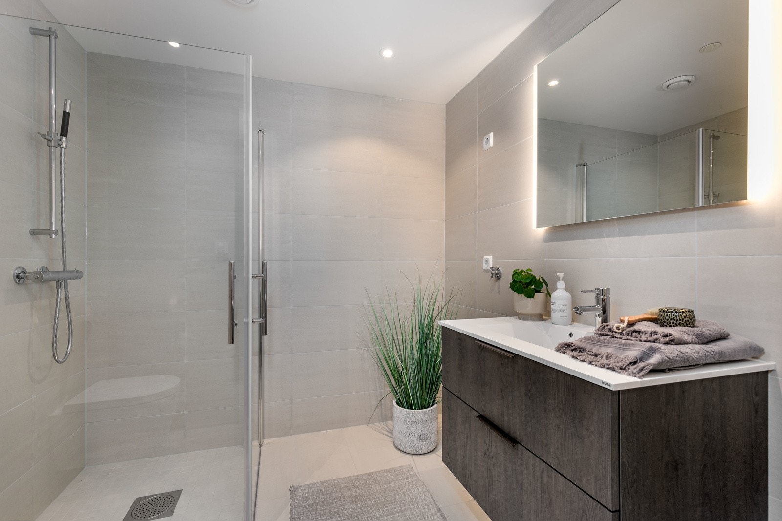 Delikat bad med flotte fliser på både vegger og gulv, downlights og gulvvarme. Lekker baderomsinnredning fra HTH av type Mood. Galleribilde