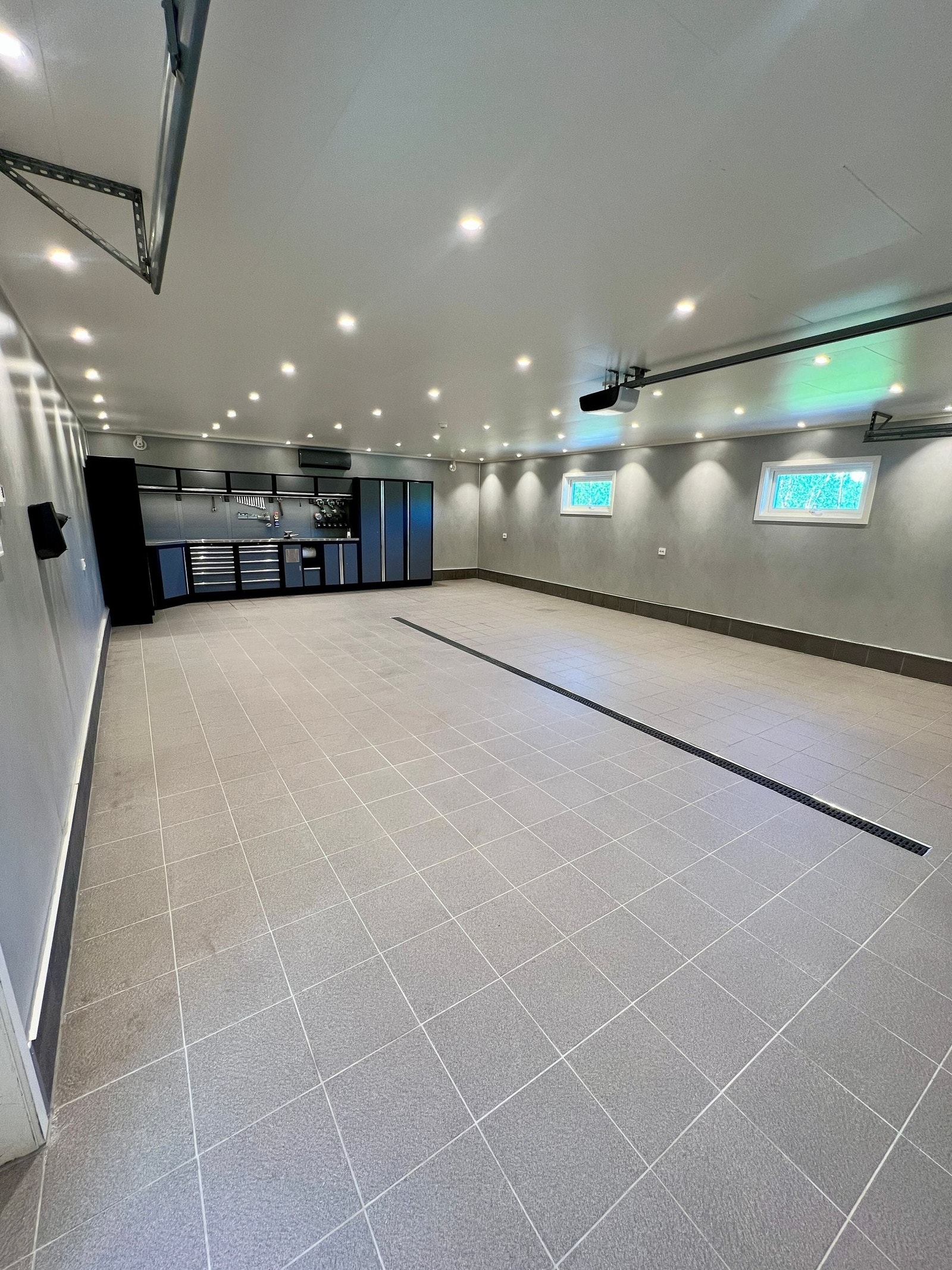 Solid og moderne garasjeinnredning. Det er i ettertid montert varmepumpe fra GREE, i tilegg er det varmekabler i gulv. Garasjen er innredet med baderomsplater på vegg og fliser på gulv, samt 2 Stk avtrekksvifter fra PAX Galleribilde