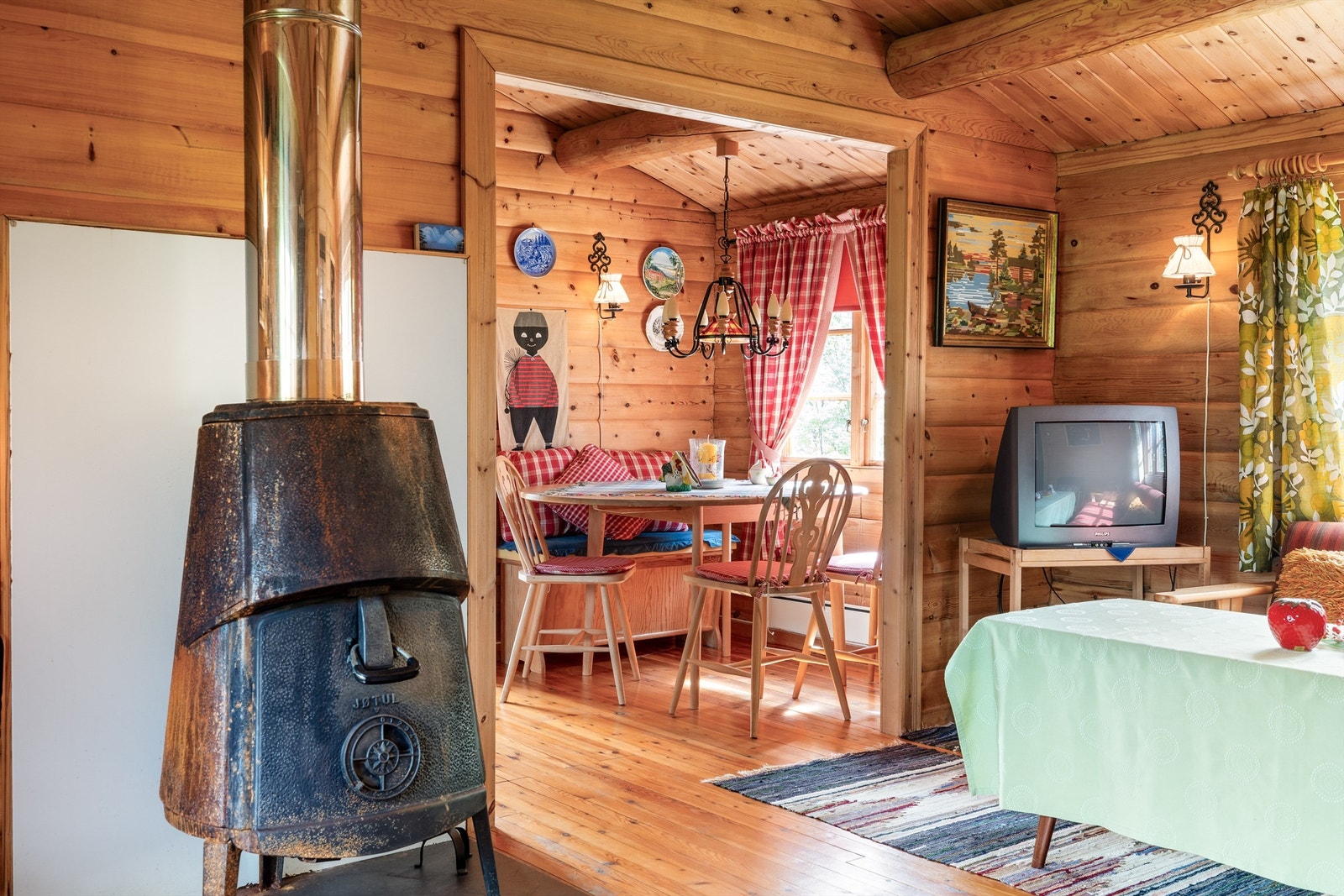 Tradisjonell hyttestil med tregulv og eldre vedovn Galleribilde