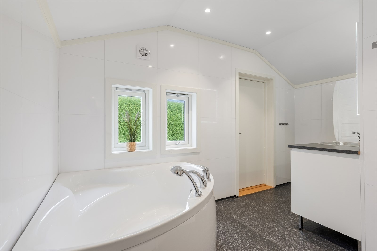 Bad/vaskerom ligger i tilknytning til hovedsoverommet og har varmekabler, downlights i himling, hjørnebadekar, innredning med nedfelt servant, veggmontert toalett og opplegg for vaskemaskin. Galleribilde