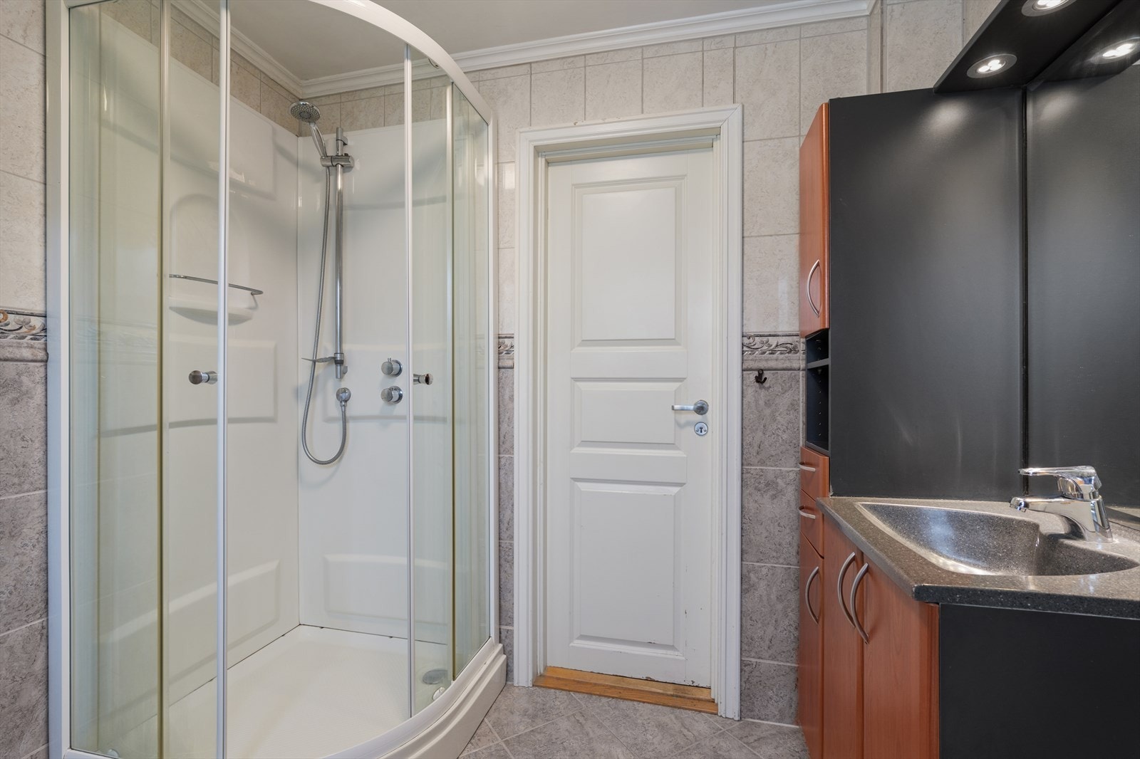 Badet er utstyrt med innredning med nedfelt servant, toalett og dusjkabinett. Galleribilde