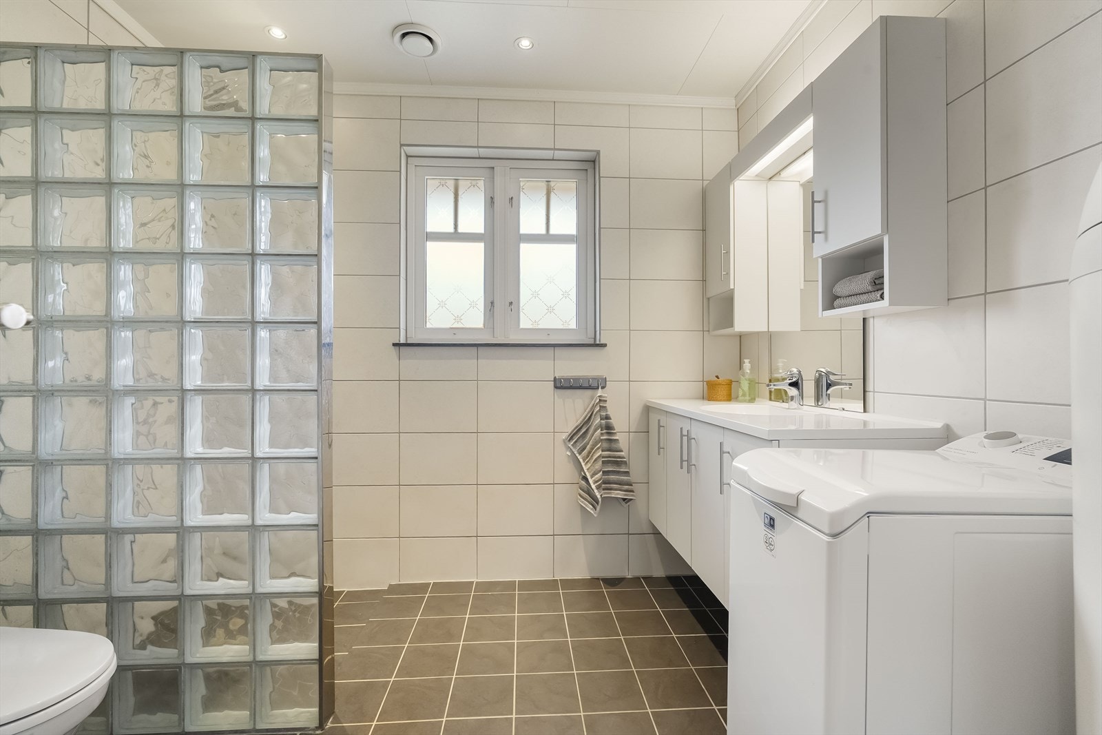 Flislagt bad med varmekabler i golv og downlights i himling Galleribilde