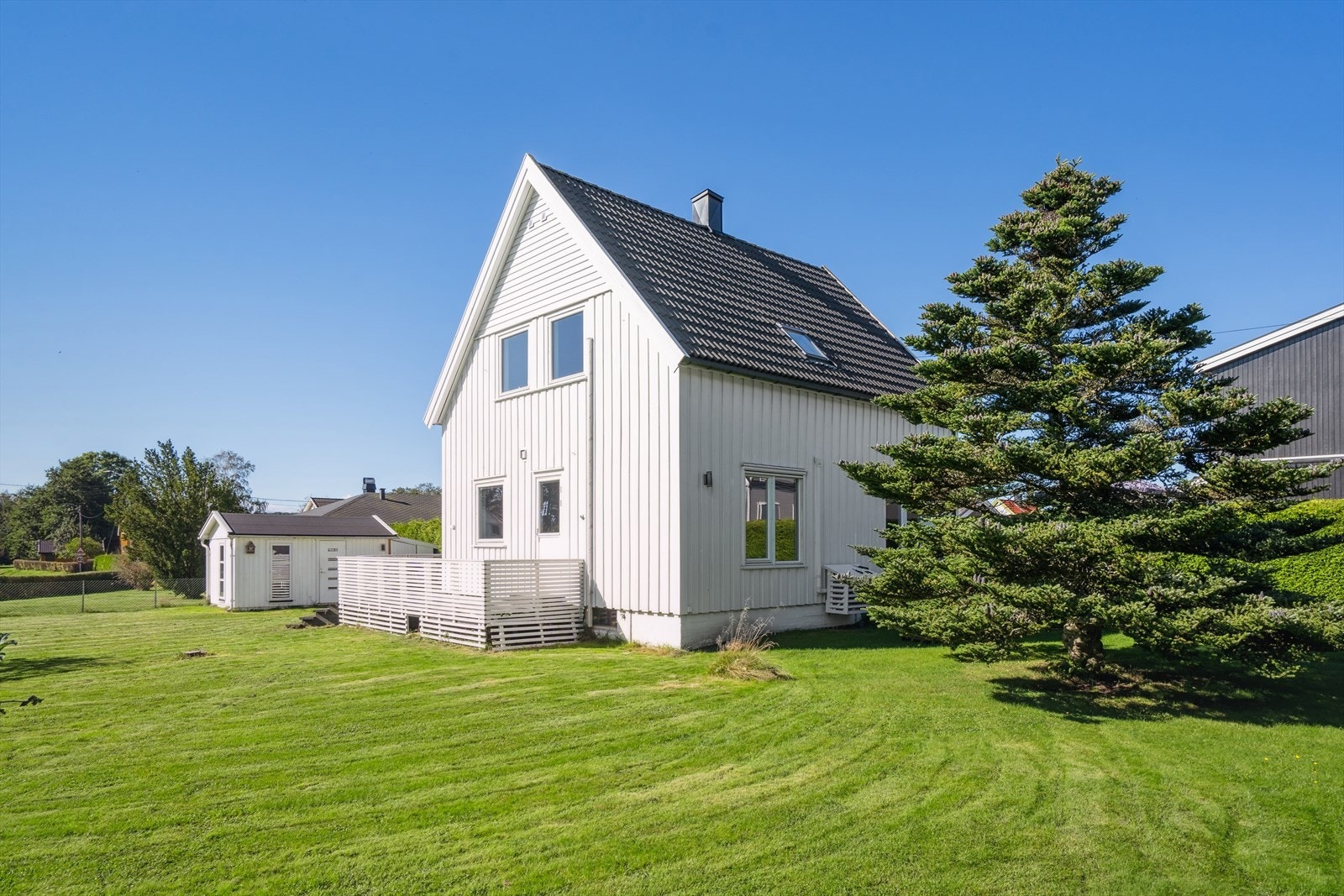 Boligen ligger tilbaketrukket og godt skjermet til med hekk fra fra gaten. Galleribilde