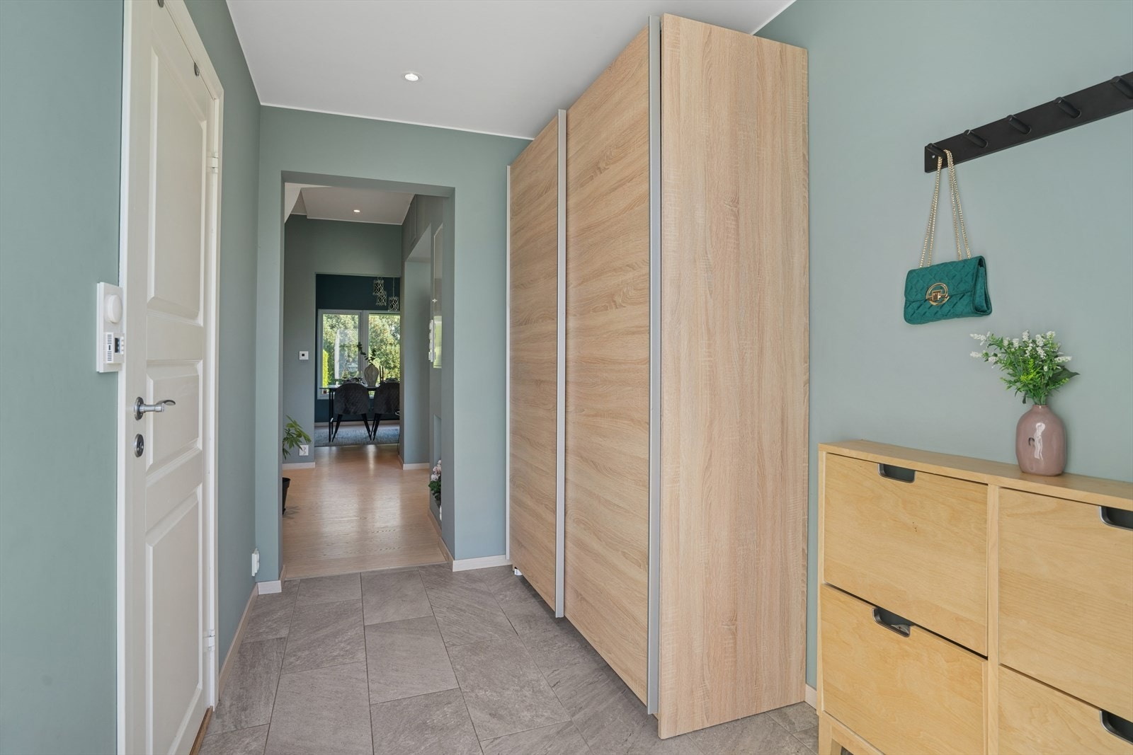 Flislagt entré med varmekabler og en praktisk skybedørsgarderobe for oppbevaring. Galleribilde