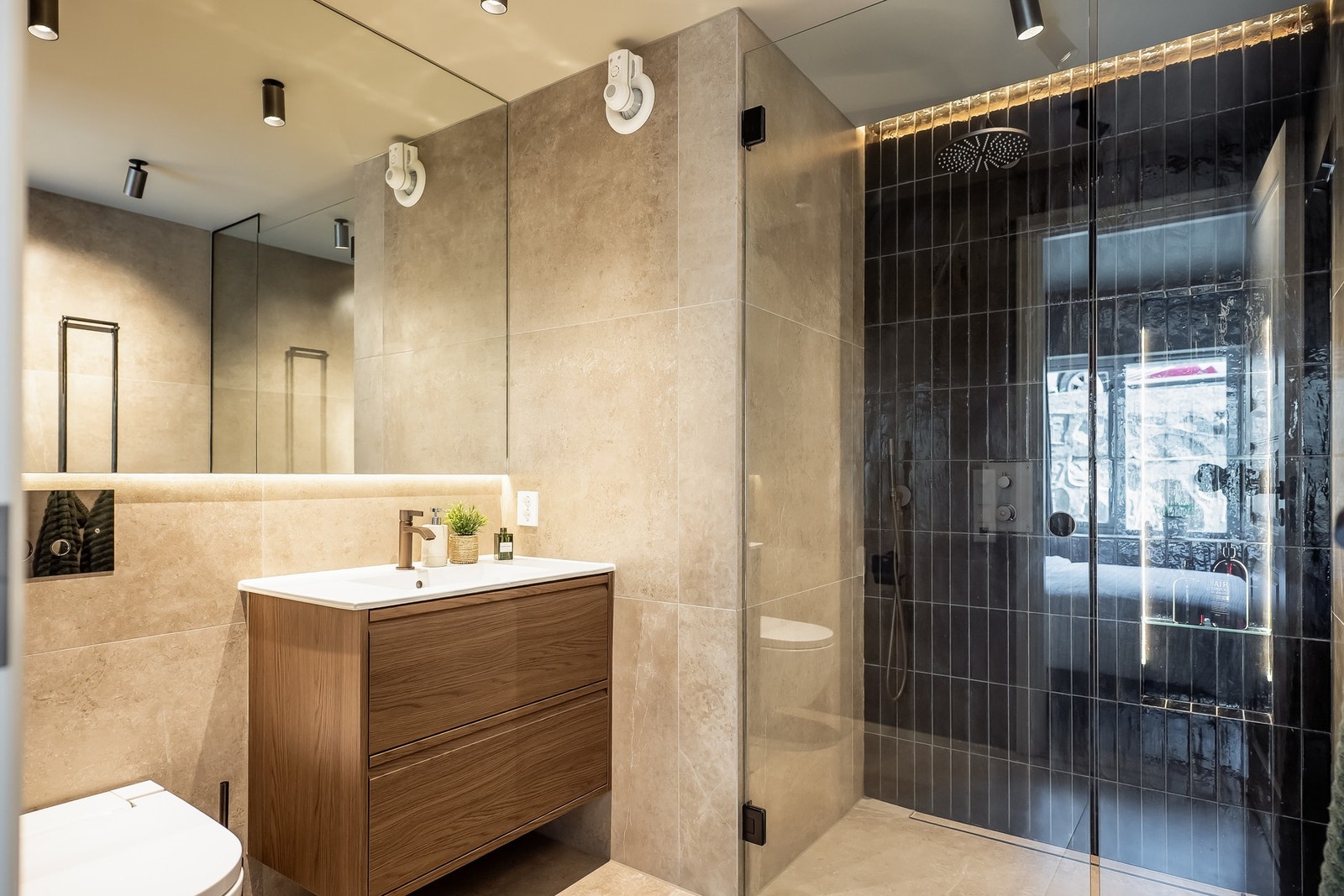 Badet her har innredning med servant, dusj, toalett og stort speil. Galleribilde