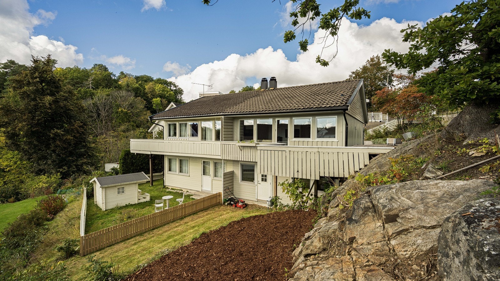 Fine uteområder med gress, fjell med anlagte blomsterbedd og fin veranda Galleribilde