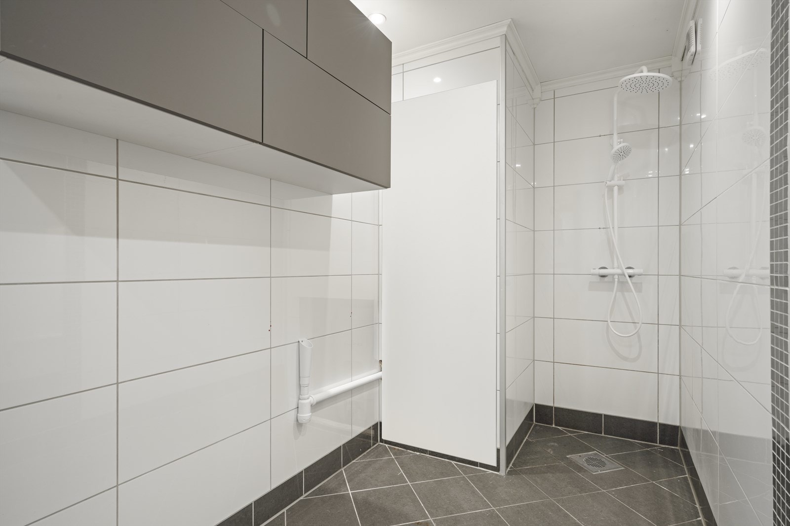 Badet er av fin størrelse og har dusjnisje, nisje for varmtvannsbereder og god plass til vaskemaskin og tørketrommel Galleribilde