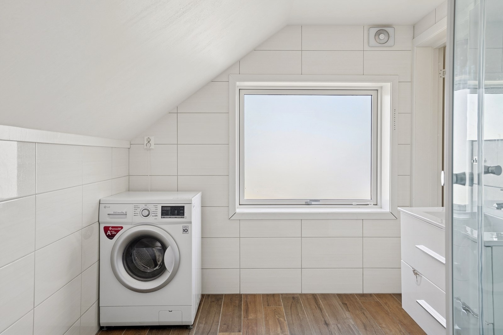 Det er utstyrt med servantinnredning, dusjkabinett, vegghengt toalett og opplegg for vaskemaskin. Galleribilde