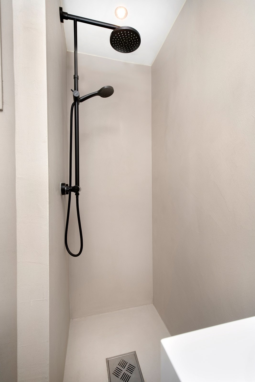 Flott gjennomført bad med bla. mikrosement og svarte detaljer. Dusjhjørne med regndusj Galleribilde