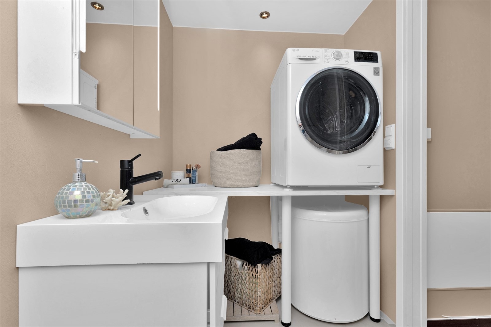 Stilrent bad med flotte baderomsmøbler. Praktisk område med "arbeidsbenk" på siden av vaskemaskin Galleribilde