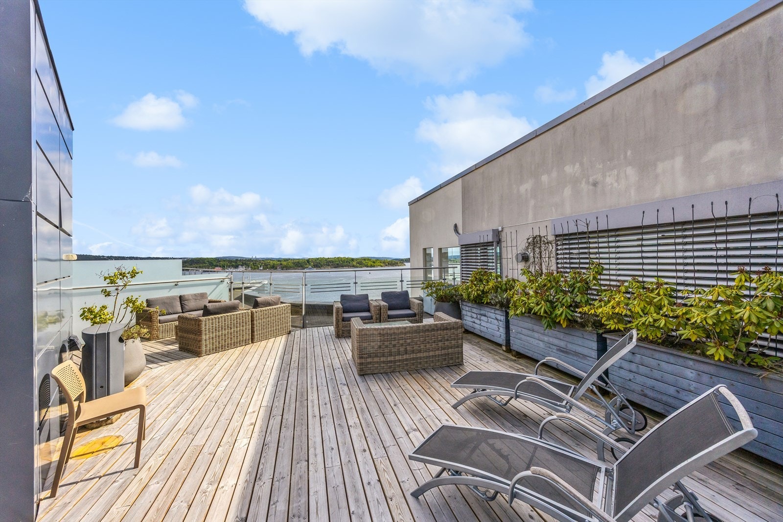 Sameiet har en rekke fasiliteter - her med solrik takterrasse med sittegrupper, planter og fjordutsikt. Galleribilde