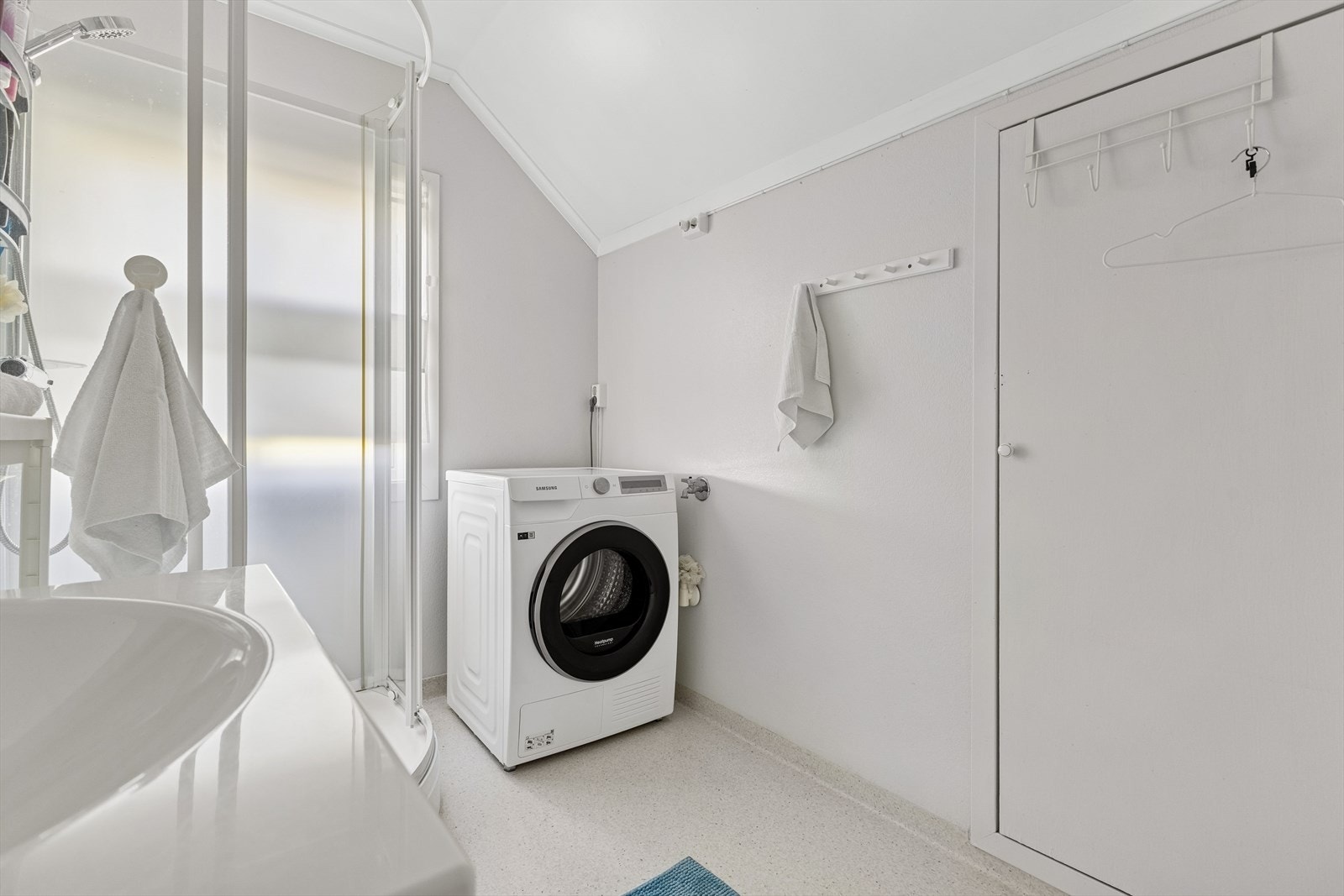 Rommet er utstyrt med servantinnredning, dusjkabinett og opplegg for vaskemaskin, noe som gjør det godt tilrettelagt for både personlig pleie og klesvask. Galleribilde