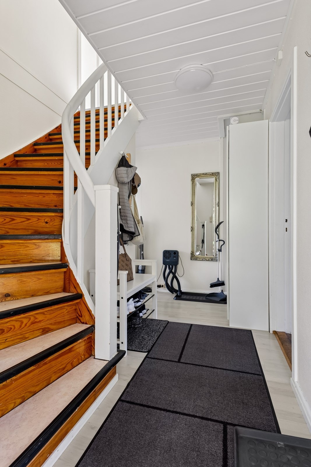 Velkommen inn i en romslig entré med god plass til oppbevaring. Her finner du trapp opp til boligens andre etasje, samt trapp ned til kjeller - perfekt for både oppholdsrom og lagring. Galleribilde