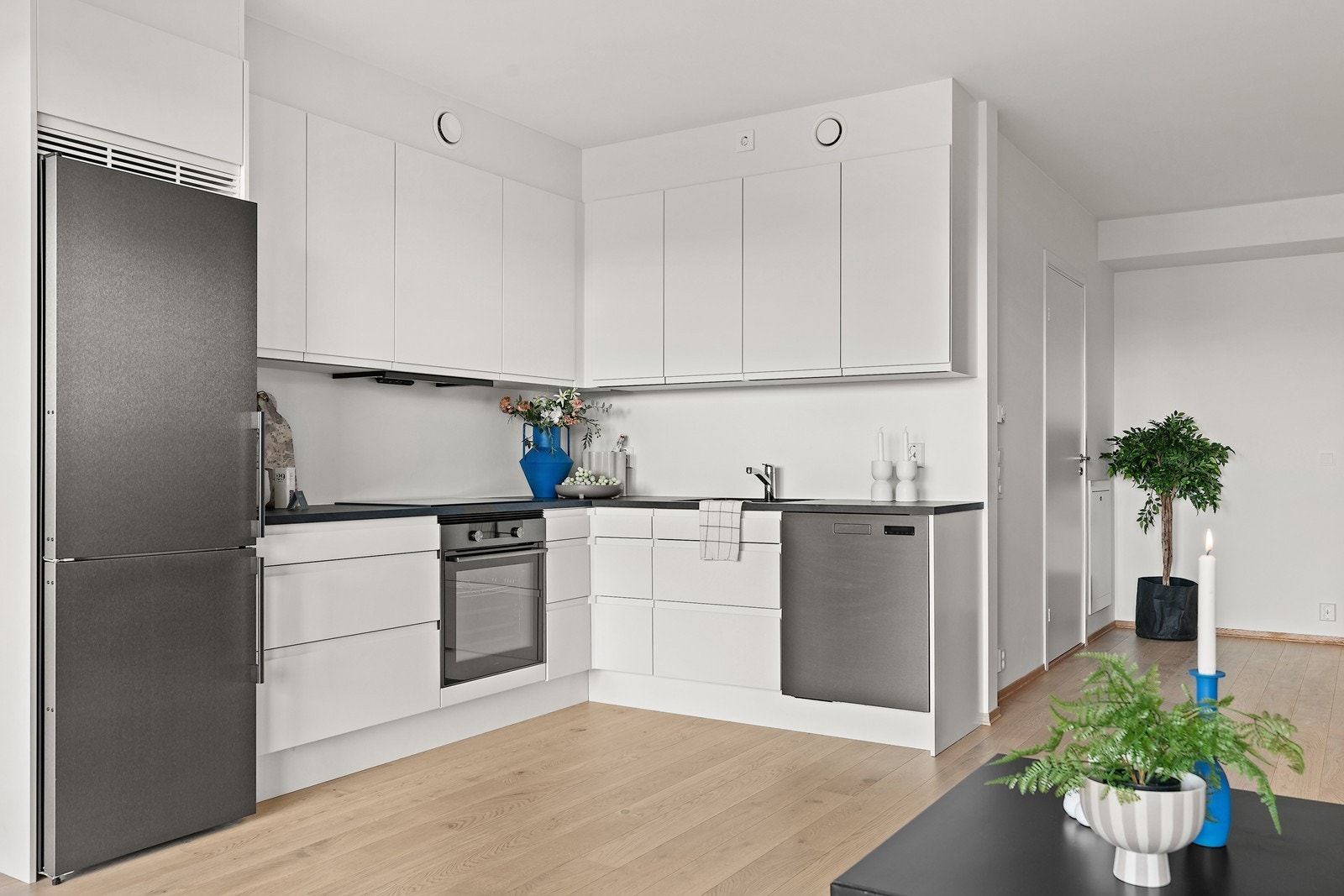 Lekkert og stilrent kjøkken med lyse slette overflater og et stilfullt design. Galleribilde