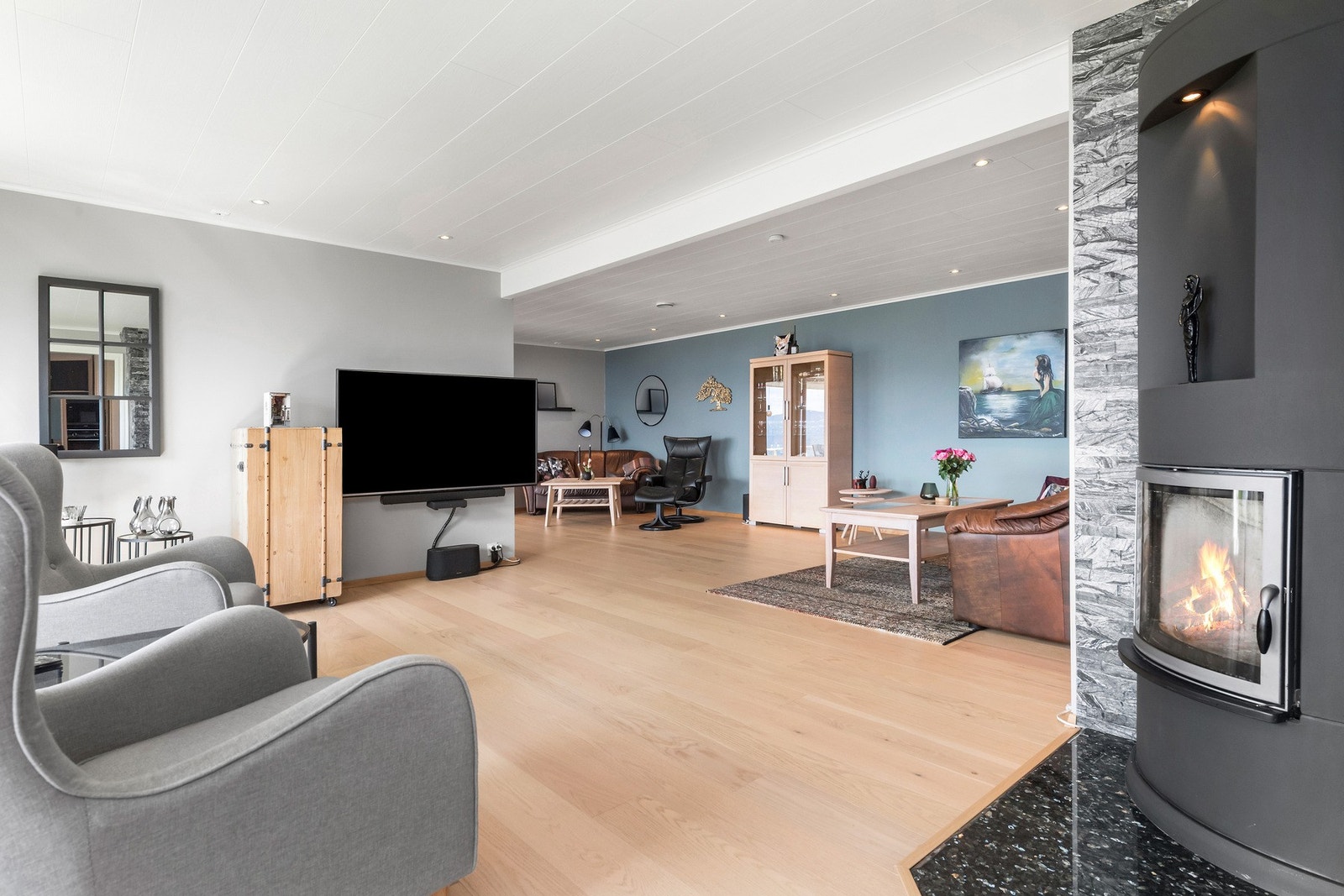 Hovedstuen ligger like ved kjøkkenet adskilt med peis Galleribilde