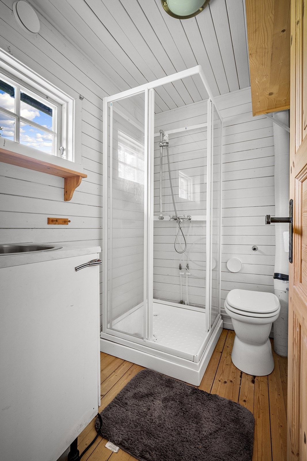 Badet er utstyrt med dusjkabinett og toalett. Galleribilde