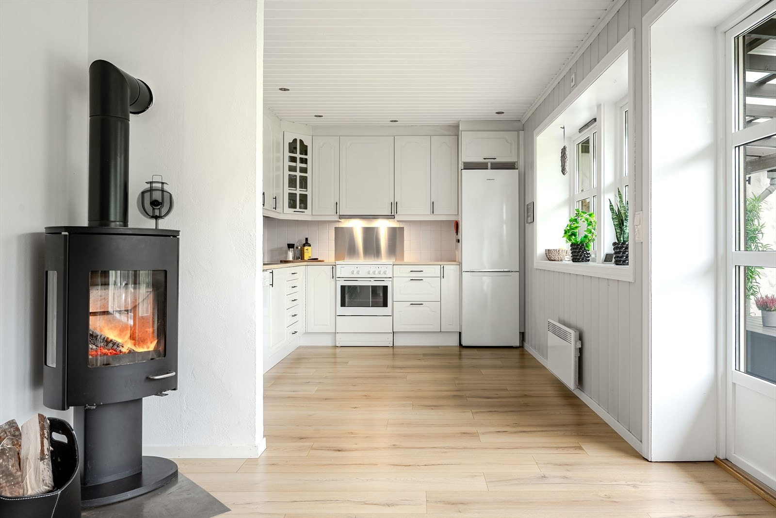 I hjørnet er det en moderne vedovn som både gir god varme og bidrar til ekstra hygge. Galleribilde