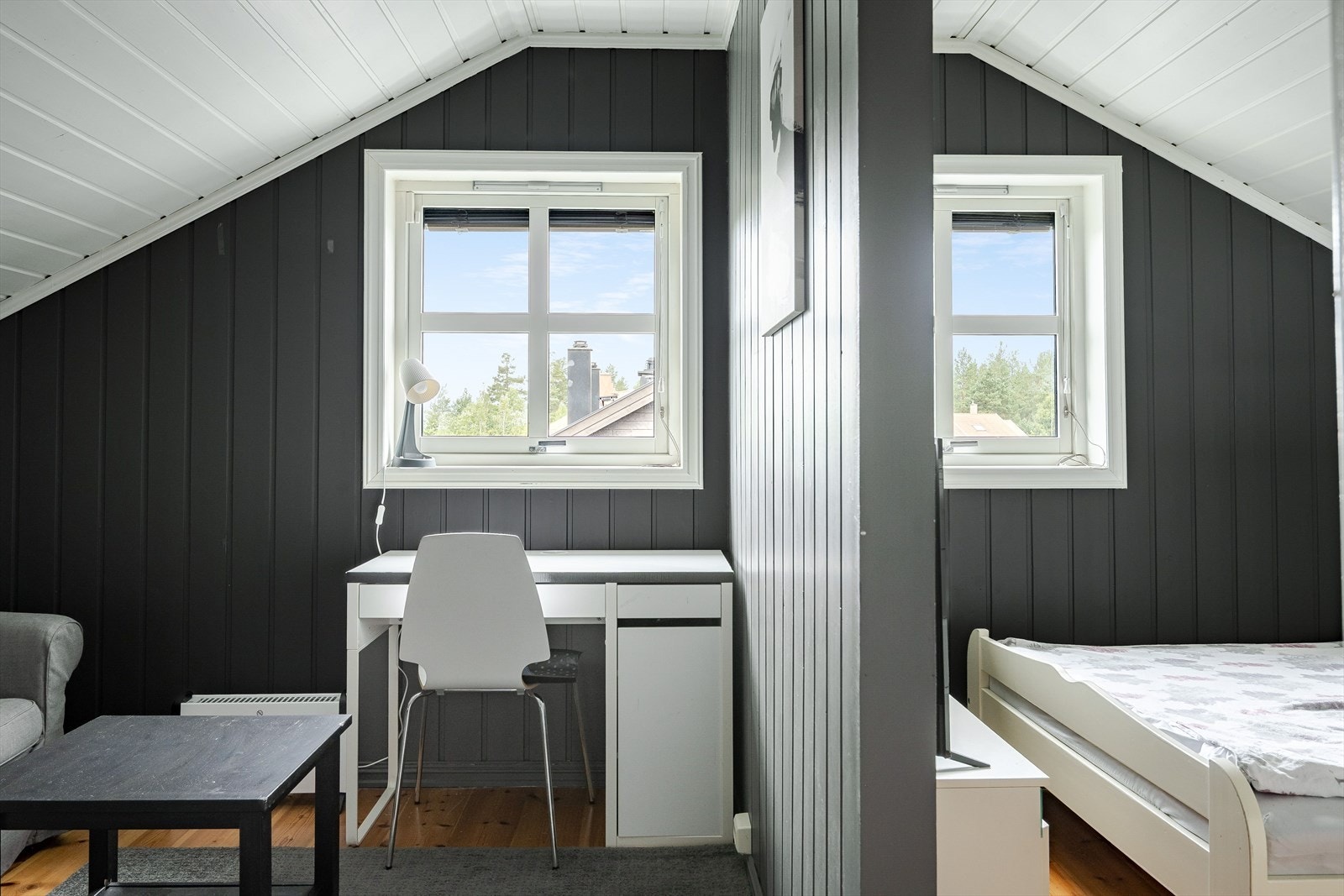 Rommet har lakkerte tregulv og mørkmalt panel på veggene. Galleribilde