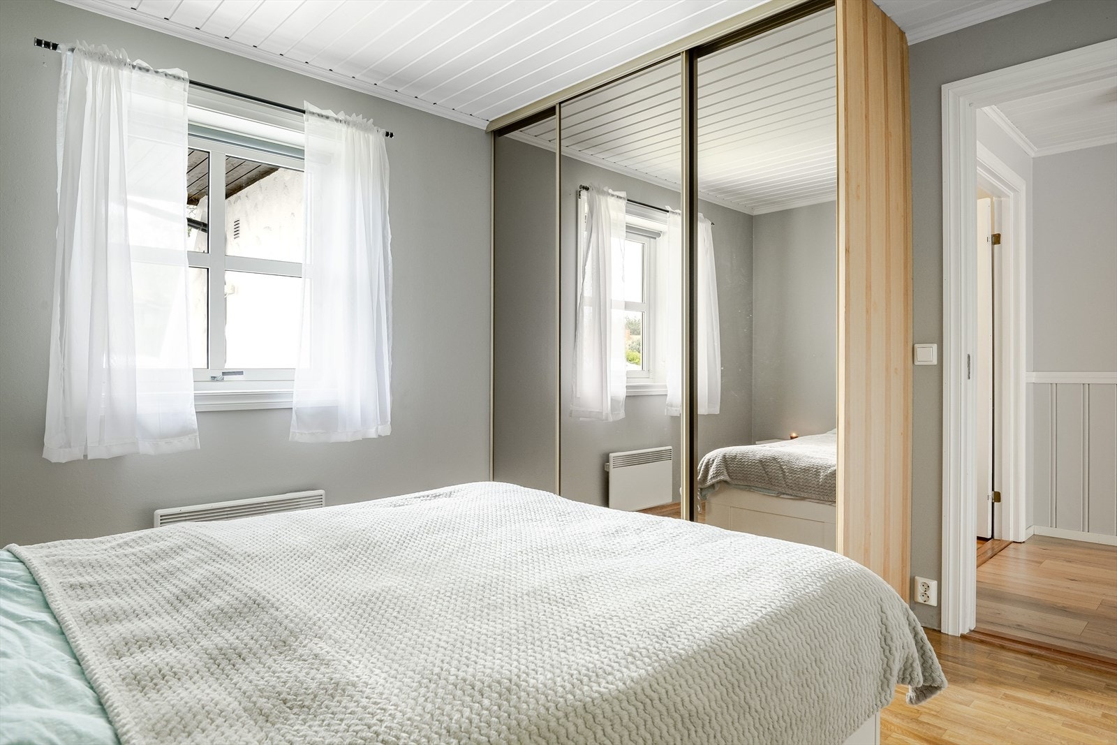 Rikelig med oppbevaringsplass i stor plassbygget skyvedørsgarderobe med speildører. Galleribilde