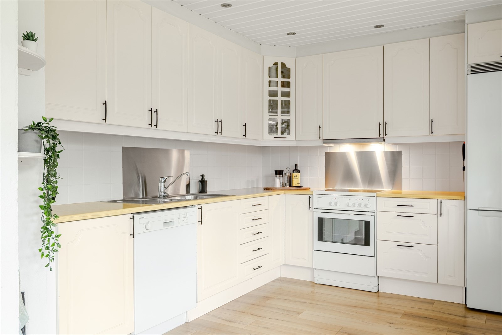 Praktisk med fliser og plater i benkeryggen. God belysning med downlights i himlingen. Galleribilde