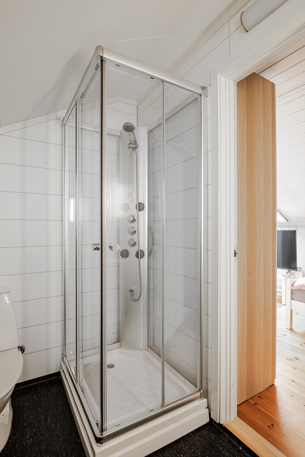 Baderommet i 2.etasje er utstyrt med moderne innredning, speil med integrert belysning, dusjkabinett og gulvstående toalett. Galleribilde