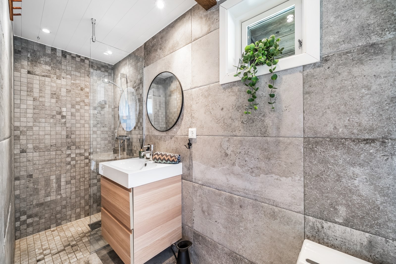 Fliselagt bad med varmekabler i gulv. Innredet med baderomsinnredning, toalett og cinderella forbrenningstoalett. Galleribilde