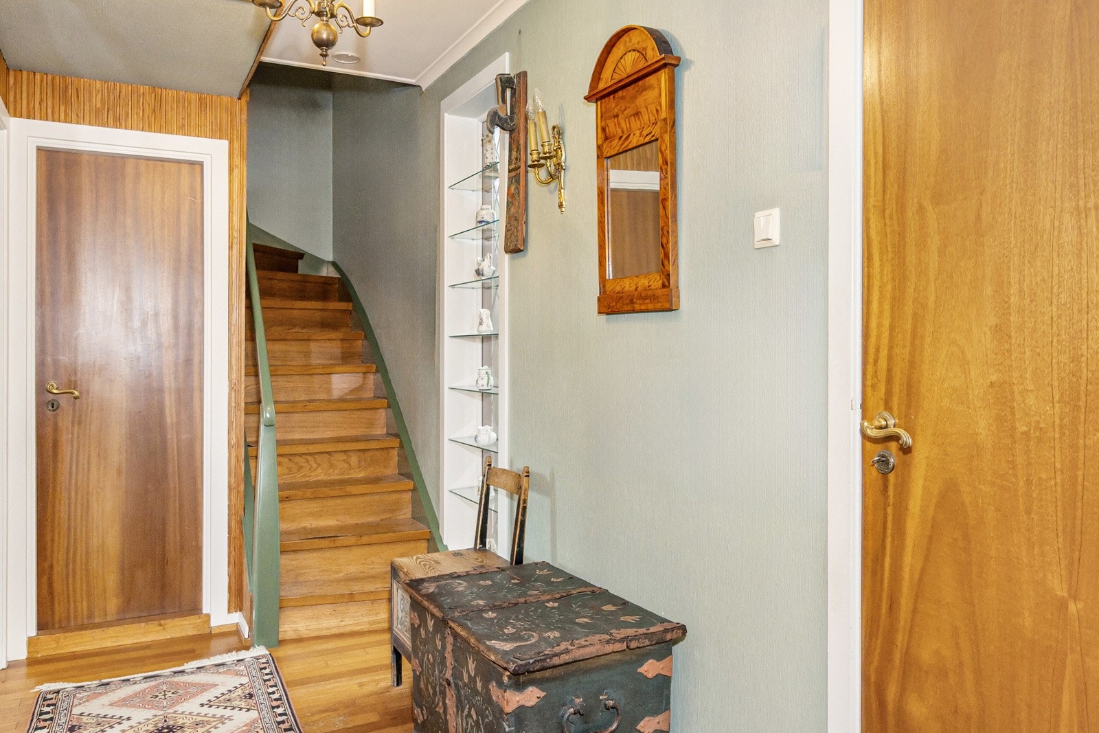 Velkommen inn! Eiendommen har et lite vindfang med plass til jakker og sko. Fra vindfanget kommer man inn døren til høyre inn i gangen hvor det er tilkomst til kjeller, 2. etg., kjøkken og stue. Galleribilde