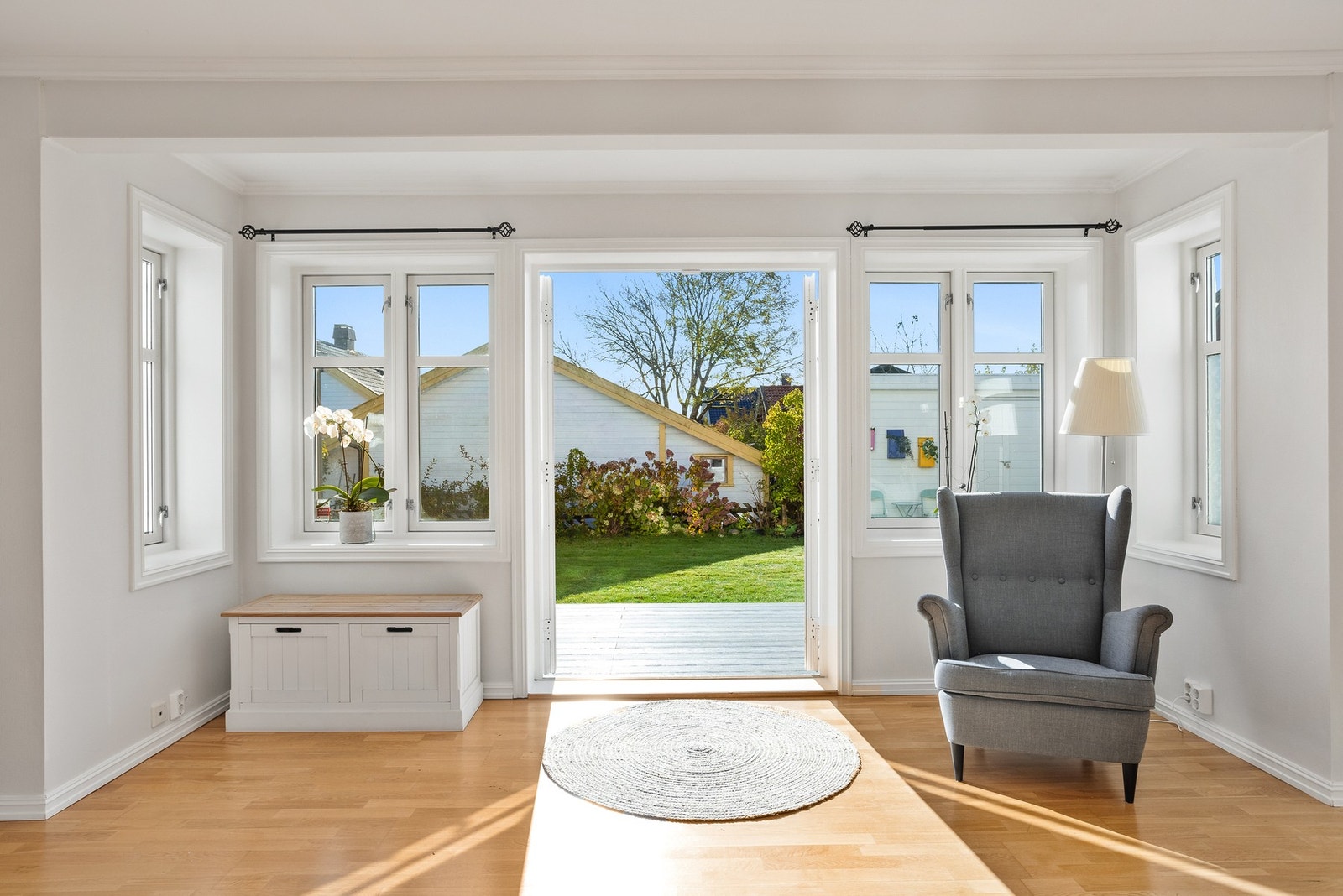 Stuen har vinduer i tre retninger som sørger for gode lysforhold, inkludert en tofløyet glassdør til terrassen i hagen Galleribilde