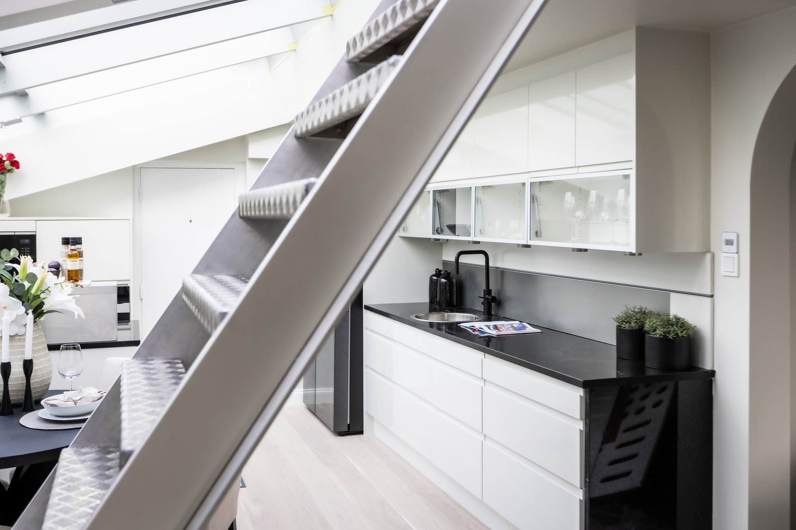 Kjøkkenbenk med sort armatur og god arbeids- og oppbevaringsplass. Trapp opp til takterrassen. Galleribilde