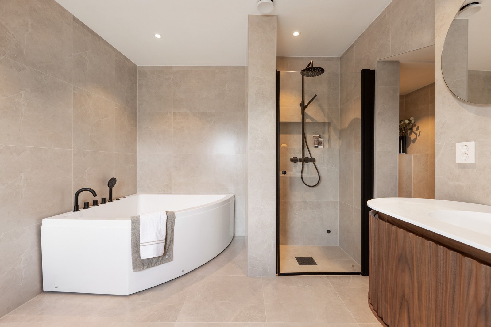 Bad fra 2025 med badekar, dusjnisje og store fliser i varme toner. Galleribilde