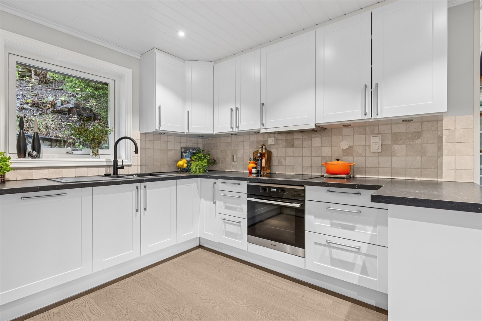 Integrert oppvaskmaskin, platetopp og stekeovn. Blandebatteri med quooker funksjon: som gir deg kaldt, varmt og kokende vann fra samme kran. Keramiske fliser over benk. Galleribilde